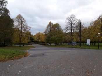 Road amidst trees against sky during autumn