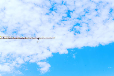 Low angle view of crane against sky