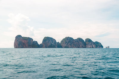 Scenic view of rock formation in sea against sky