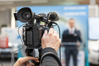 Cropped hand of person photographing live event