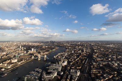 Aerial view of tower bridge over river amidst buildings in city against sky