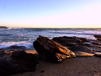 Scenic view of sea against clear sky at sunset