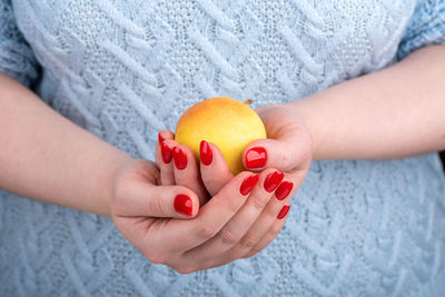 Midsection of woman holding granny smith apple