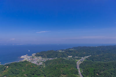 High angle view of sea and mountains against blue sky