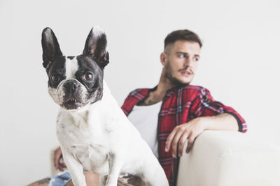 Man with dog on sofa against white background