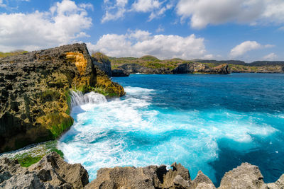 Scenic view of rocks in sea against sky