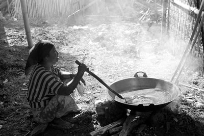Side view of woman preparing food in utensil
