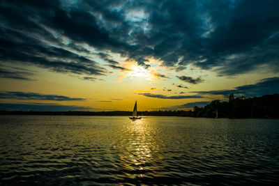 Scenic view of sea against dramatic sky during sunset