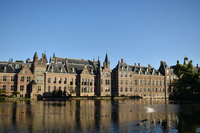 Reflection of  netherlands parliament building in water against clear blue sky