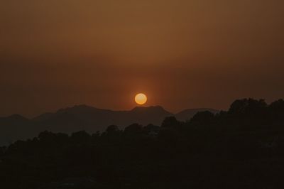 Scenic view of silhouette mountains against sky during sunset