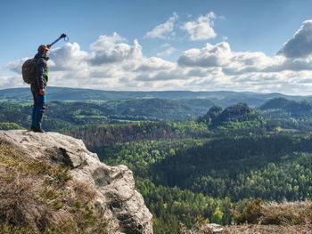 Man with walking sticks on mountain hill near edge. trekking sticks for nordic walking