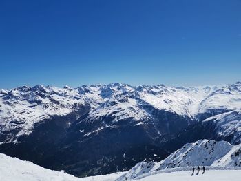 Scenic view of snowcapped mountains against clear blue sky