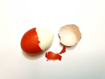 Close-up of broken egg against white background