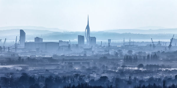 View of cityscape against sky during foggy weather