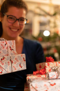 Portrait of a smiling young woman holding christmas gifts