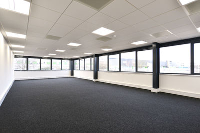 View of a new empty office area with windows on two sides and carpeted