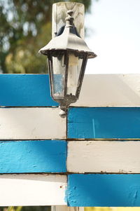 Low angle view of lamp against building wall
