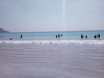 People on beach against sky