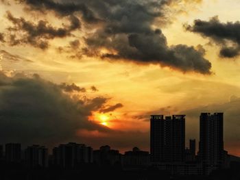 View of cityscape against cloudy sky during sunset