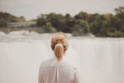 Rear view of woman standing against sky