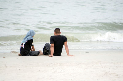 Rear view of men on beach