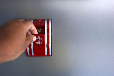 Close-up of hand holding red wall