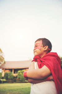 Boy with cape and eye patch playing in park