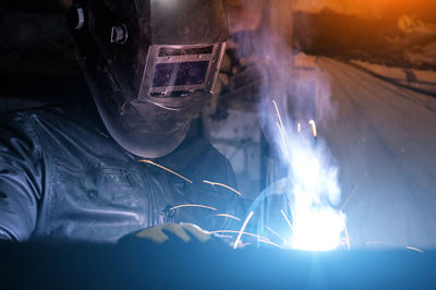 Craftsman works in his old garage on an order, metal welding