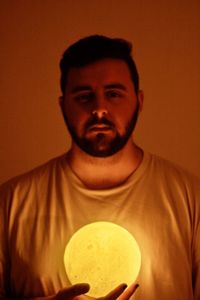 Portrait of young man standing against wall