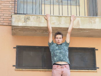 Portrait of man hanging from balcony