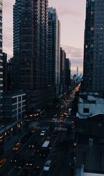 Traffic on city street by buildings against sky