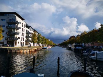 River amidst buildings in city against sky