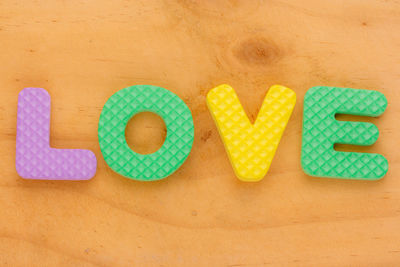 Close-up of colorful love text on wooden table