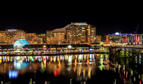 Illuminated cityscape against clear sky at night