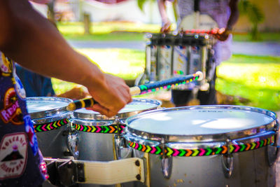 Midsection of man playing drum