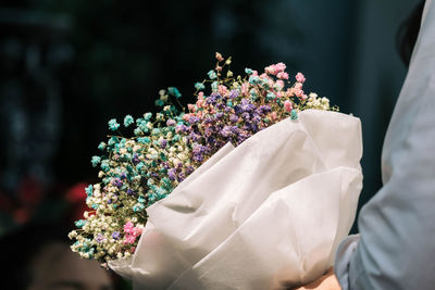 Midsection of woman with flower bouquet