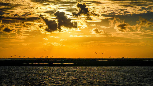 Scenic view of sea against orange sky during sunset