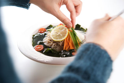 Midsection of woman holding fruit in plate