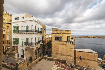 Buildings in city against cloudy sky