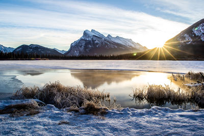 Scenic view of lake and snowcapped mountains against sky during winter