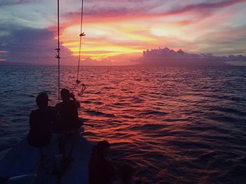 Silhouette of people in sea at sunset