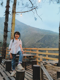 Full length of kid standing on mountain against sky