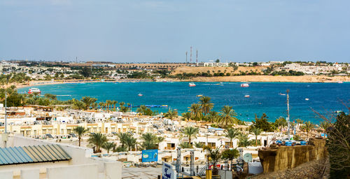 High angle view of town by sea against clear sky