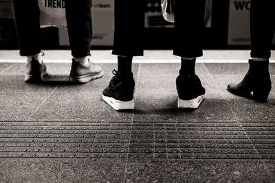 Low section of people standing at railroad station platform