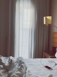 View of messy bed in bedroom