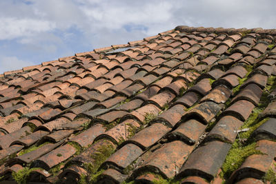 Low angle view of roof tiles against sky