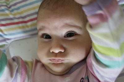 Close-up portrait of cute baby girl in bed