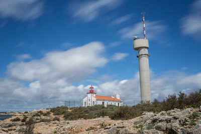 Low angle view of lighthouse against buildings