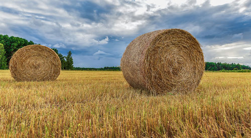 Hay bales on field against sky