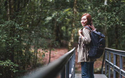 Portrait of woman standing against trees